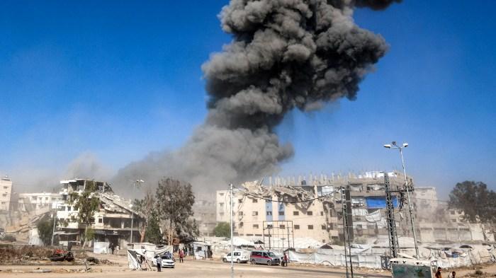 Smoke rising over damaged buildings